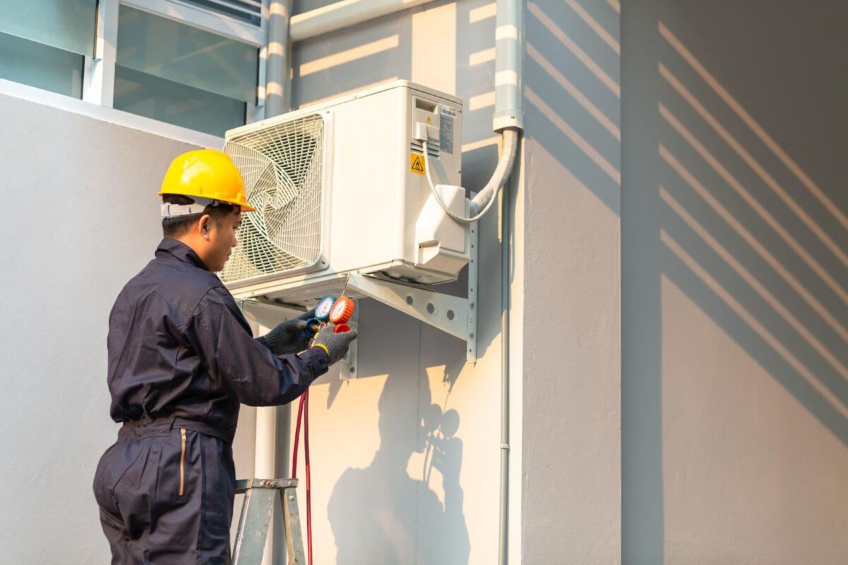 Air conditioner technician servicing a unit