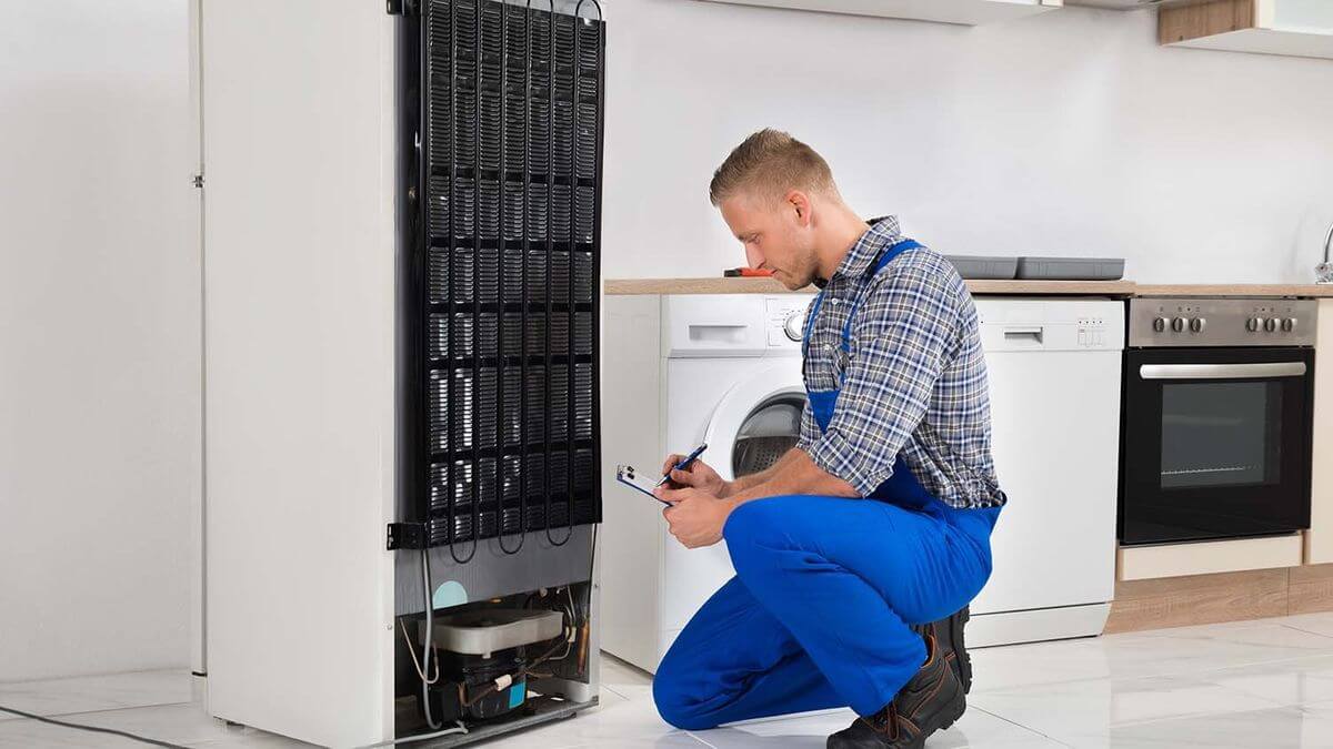 Technician repairing a fridge in a Cape Town home