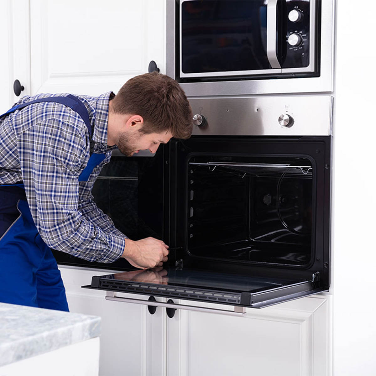 Technician inspecting an oven heating element